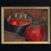 Three bright red tomatoes (two in a reflective stainless steel bowl, one left out on the counter)