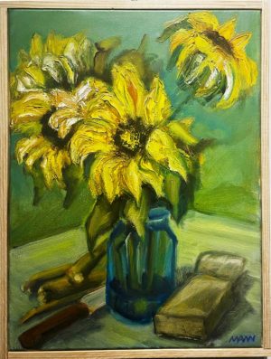 Vase of sunflowers on an outdoor table, with shears and trimmed stems
